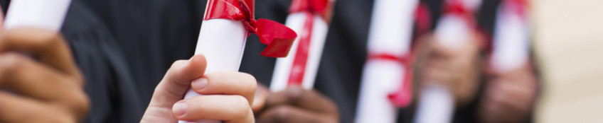 dettaglio: mani che stringono i diplomi legati di nastro rosso